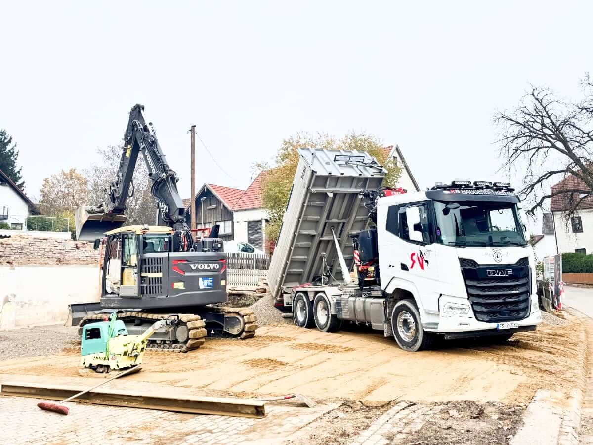 LKW mit Ladekran beim Transport und Verladen von Baumaterial auf Baustelle in Freising